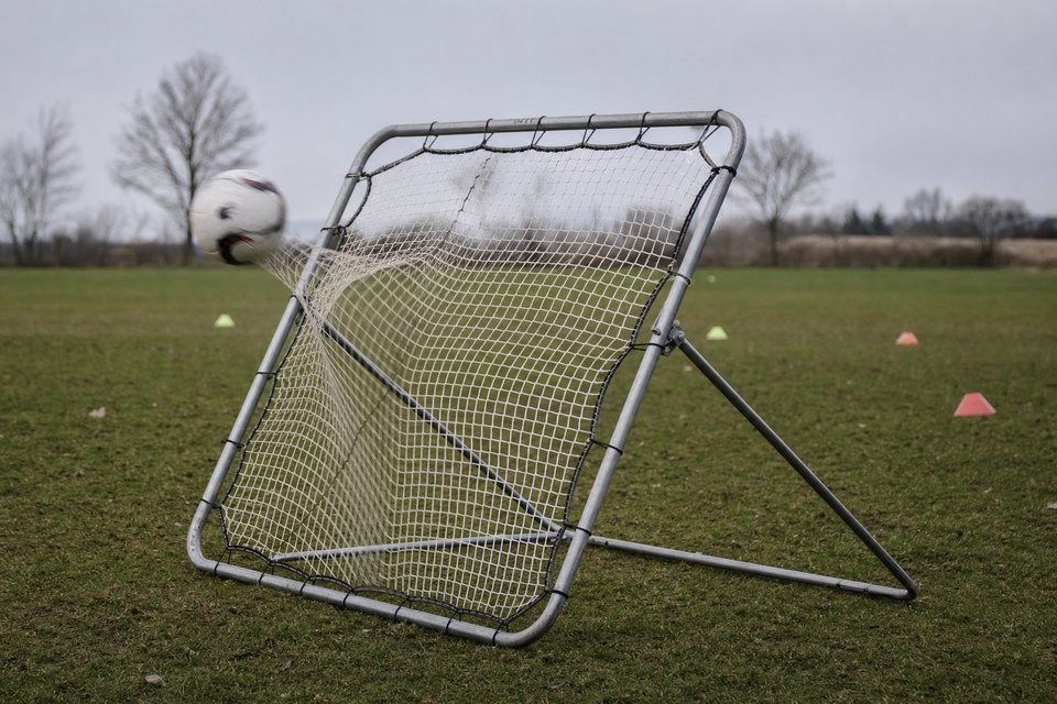 Rebounder na skraju boiska treningowego, piłka odbija się od siatki